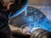 A production employee of the Schmid company welds together a screw discharge in Poland.